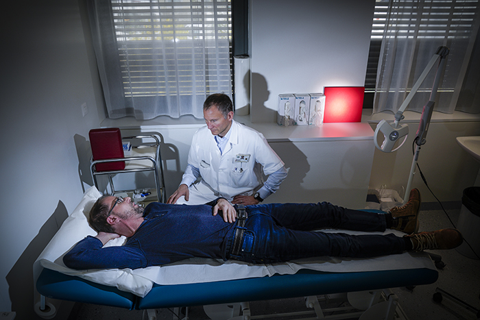 A man is laying on a bed in a hospital room