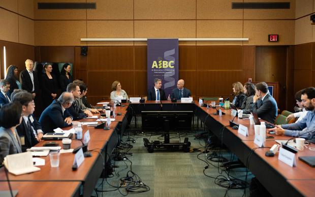 A diverse group of individuals gathered around a long table, engaged in conversation and sharing ideas.
