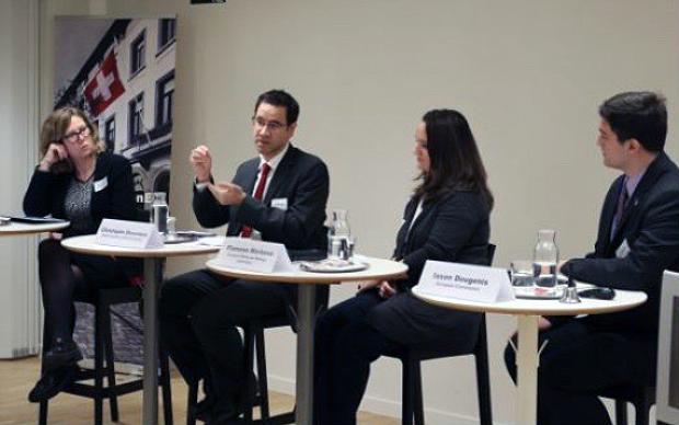 Picture of 4 people sitting at a conference and speaking together