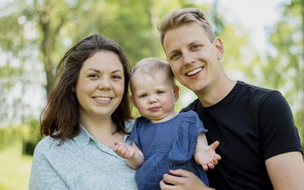 Photo of a woman and man holding a baby