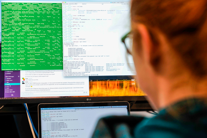 A men is looking at a computer screen with code on it