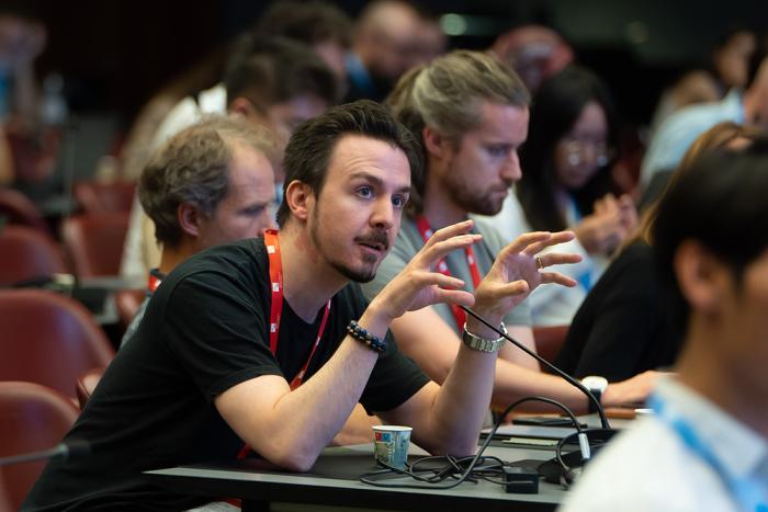 A man asking a question in the crowd of a scientific conference