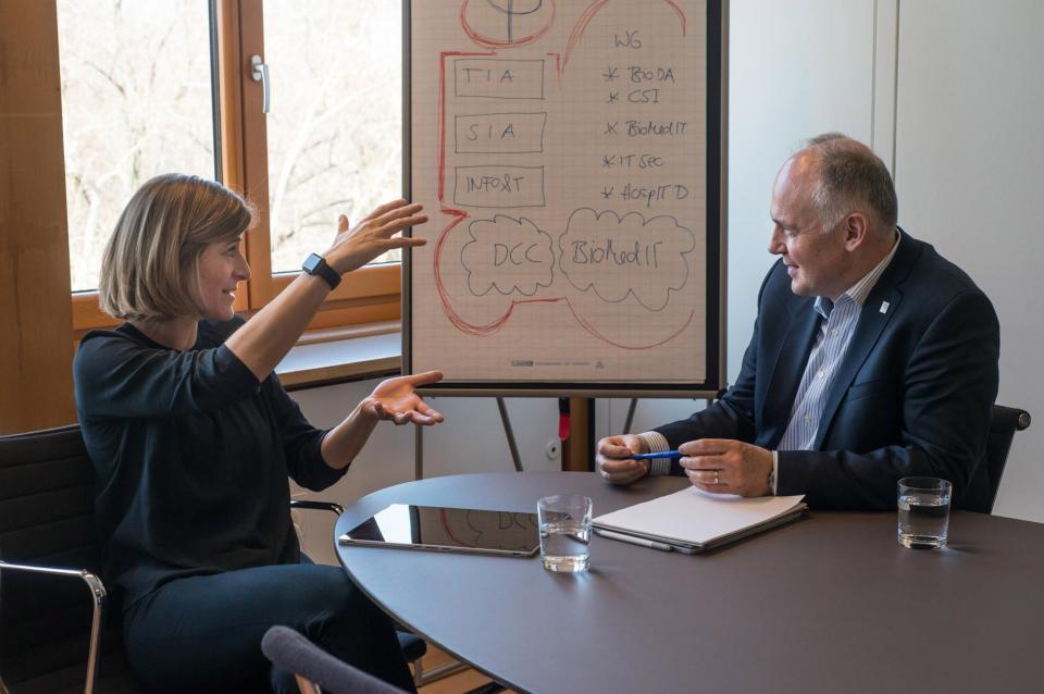 a woman is talking to a man at a table